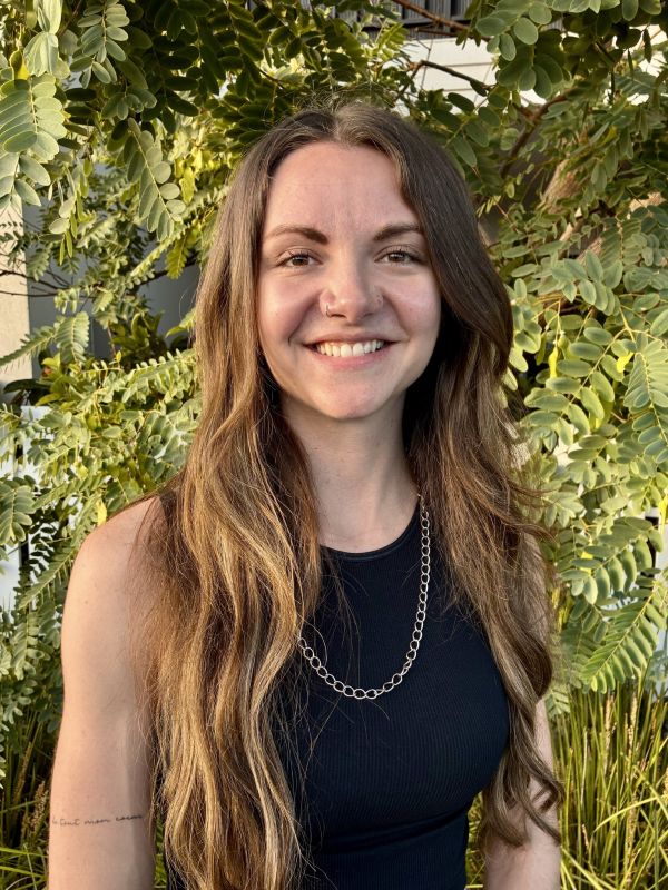 Zaneta Neucom smiling in a black shirt outdoors.